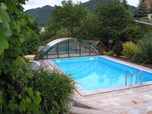 a swimming pool with a glass greenhouse around it at Gästehaus Lumesberger in Grein