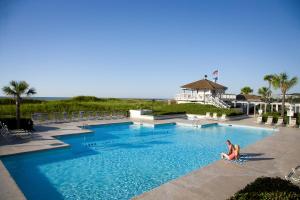 a woman sitting in a swimming pool at a resort at Ocean Creek Resort in Myrtle Beach