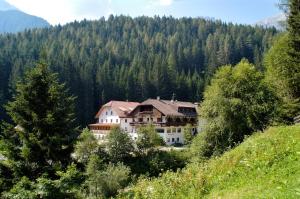 a large house in the middle of a mountain at Residence Bad Bergfall in Valdaora