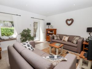 a living room with two couches and a table at Walnut Barn in Belper