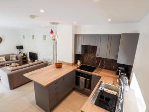 an open kitchen and living room with a couch at Walnut Barn in Belper