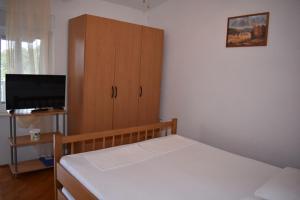 Schlafzimmer mit einem Bett und einem Holzschrank in der Unterkunft Holiday apartment in Drage with terrace, air conditioning, W-LAN 5013-5 in Drage