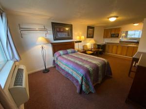 a hotel room with a bed and a desk at Round-Up Motel in Cheyenne