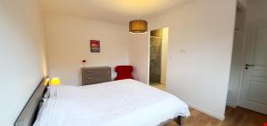 リ・エ・ミックスにあるVilla cork contis 1のベッドルーム(白いベッド1台、赤い椅子付)