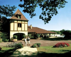 un hombre está parado frente a un edificio en Résidence Les Hauts de Marquay, en Marquay