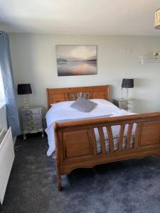 a bedroom with a large wooden bed and two lamps at Causeway View perfect for large golf groups seafront central location, pet friendly, see dolphins in Portrush