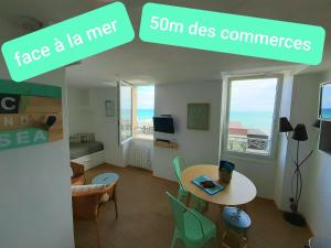 a living room with a table and chairs and a dining room at LUC and SEA in Luc-sur-Mer +6 photos