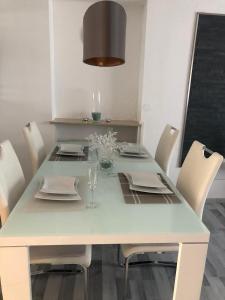 于伯林根的住宿－Waldkristall，餐桌、白色椅子、白色桌子和灯