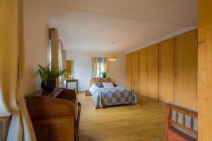 オンフルールにあるA L'ecole Buissonniereのウッドフロアのベッドルーム1室(ベッド1台、木製キャビネット付)