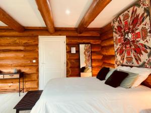 - une chambre avec un lit dans une pièce dotée de murs en bois dans l'établissement AU COTTAGE DU MEDOC - Proche BORDEAUX, à Saint-Aubin-de-Médoc