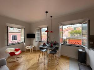 ein Wohnzimmer mit einem Tisch und 2 Fenstern in der Unterkunft Mare e Cielo Luxury Apartment 2BR in Sestri Levante