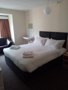 a bedroom with a large bed with two towels on it at Black Lion in Scarborough