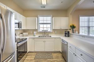 a kitchen with white cabinets and a stainless steel refrigerator at North Myrtle Beach Condo with Private Balcony! in Myrtle Beach