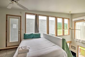 een slaapkamer met een bed met blauwe kussens en ramen bij Cozy-Chic Abode Hang Glide, Hike, Rock Climb in Trenton