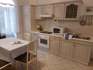 a kitchen with white appliances and a table and a table and a table at Appartements Andrea in Klosterneuburg