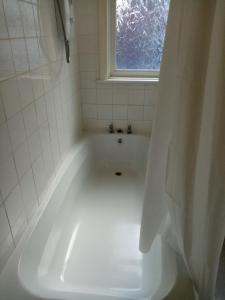 Una bañera blanca en un baño con ventana. en Black Lion, en Scarborough