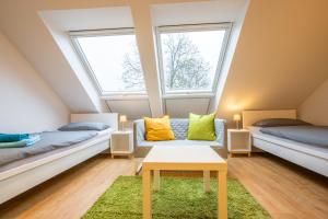 a attic room with two beds and a couch at Wohnen wie zu Hause in Essen