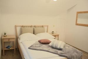 Una cama con sábanas blancas y una manta. en Ferienwohnung Traumzeit, en Cochem