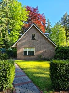 een stenen huis met een pad ervoor bij Het Roodborstje in Otterlo