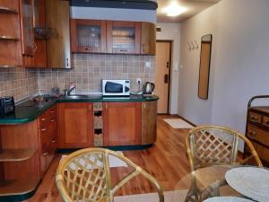 Una cocina con gabinetes de madera y microondas. en Polanica Centrum, en Polanica-Zdrój