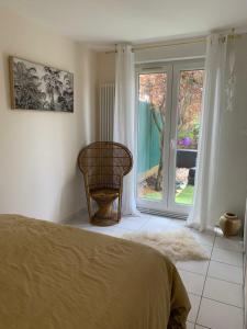 a bedroom with a bed and a window and a chair at Appartement REZ DE JARDIN avec SPA entre la MER et Montpellier 10mn in Lattes