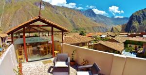 a balcony with a view of a village and mountains at Kamma Guest House in Ollantaytambo