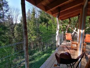 a porch of a cabin with chairs on it at La Fortance Paradis Naturel - Proche de la ville in Planfoy