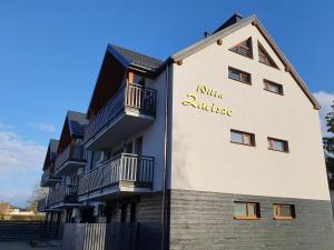 a building with a sign on the side of it at Willa Zacisze apartament 12 in Kąty Rybackie