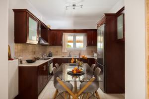 une cuisine avec une table en verre et des chaises. dans l'établissement michael apartments, à Corfou