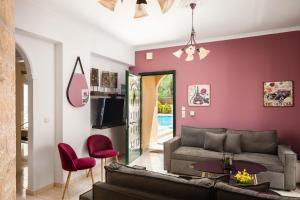 a living room with a couch and red accent wall at michael apartments in Corfu Town