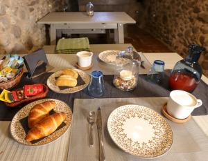 a table with plates of croissants and bread on it at B&B Luna & Stelle in Villafranca in Lunigiana