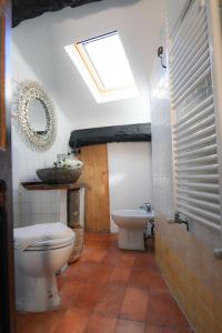La salle de bains est pourvue de toilettes, d'un lavabo et d'une lucarne. dans l'établissement B&B Luna & Stelle, à Villafranca in Lunigiana