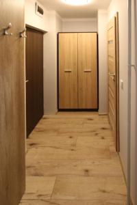 pasillo con suelo de madera y 2 puertas en Apartament Navigare en Kołobrzeg