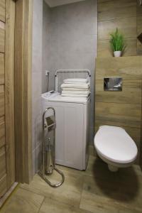 a bathroom with a white toilet and a sink at Apartament Navigare in Kołobrzeg