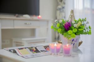 stół z dwoma świecami i kwiatami oraz magazyn w obiekcie Villa Rita w mieście Promajna