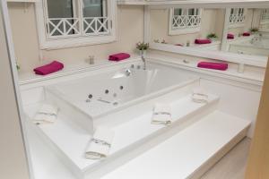 biała łazienka z 2 umywalkami i lustrami w obiekcie Villa Rita w mieście Promajna