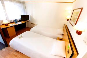 a hotel room with two beds and a desk at Campanile Besançon-Ouest Châteaufarine in Besançon