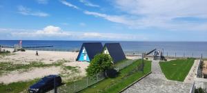 un coche aparcado junto a una playa con la carta en GARDENIA Apartament Przy Plaży 19, en Dziwnów