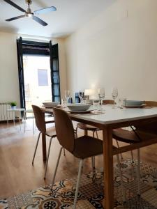 a dining room with a table and chairs with wine glasses at Apartment Histórico in Girona