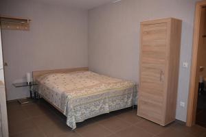 1 dormitorio pequeño con 1 cama y armario de madera en Ferienwohnung an der Obermosel, en Oberbillig