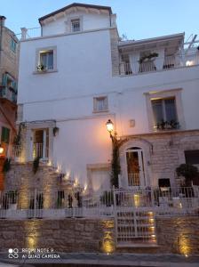 un bâtiment blanc avec une clôture blanche devant lui dans l'établissement Torre Pendio b&b, à Corato