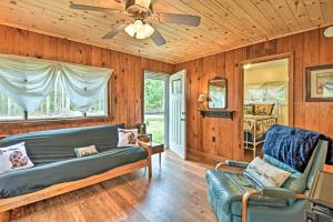 a living room with a couch and a ceiling fan at Gateway to Boyne Mtn! 'Nestle by Lake' Cottage in Charlevoix
