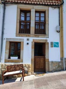 a bench in front of a building with windows at LA CASINA DEL CARRIL in Colunga
