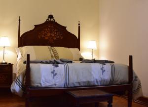 a large bed in a bedroom with two lamps at Batalhoz House in Cartaxo