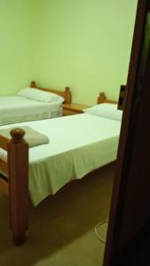 2 Betten in einem Zimmer mit weißer Bettwäsche in der Unterkunft Mas de l'Assut in Cornudella de Montsant