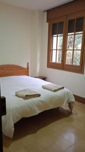 Schlafzimmer mit einem großen weißen Bett und einem Fenster in der Unterkunft Mas de l'Assut in Cornudella de Montsant