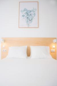 Un dormitorio con una cama blanca y una foto en Sweet Stays, en Las Palmas de Gran Canaria