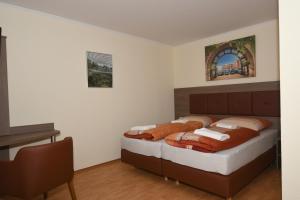 a bedroom with two beds and a desk at Ellen Hotel in Flensburg