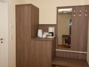 a kitchen with a coffee maker and a mirror at Ellen Hotel in Flensburg