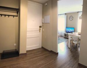 een lege kamer met een deur, een tafel en een bureau bij Apartamento acogedor y familiar - WiFi+Chromecast in Puigcerdà +8 foto's